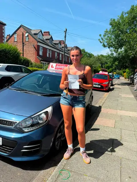 A Learners' Club pupil holding their driving test pass certificate