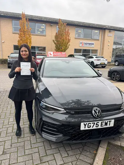 A Learners' Club pupil holding their driving test pass certificate