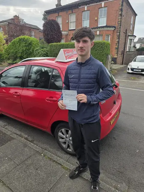 A Learners' Club pupil holding their driving test pass certificate