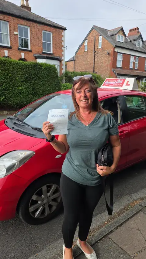 A Learners' Club pupil holding their driving test pass certificate